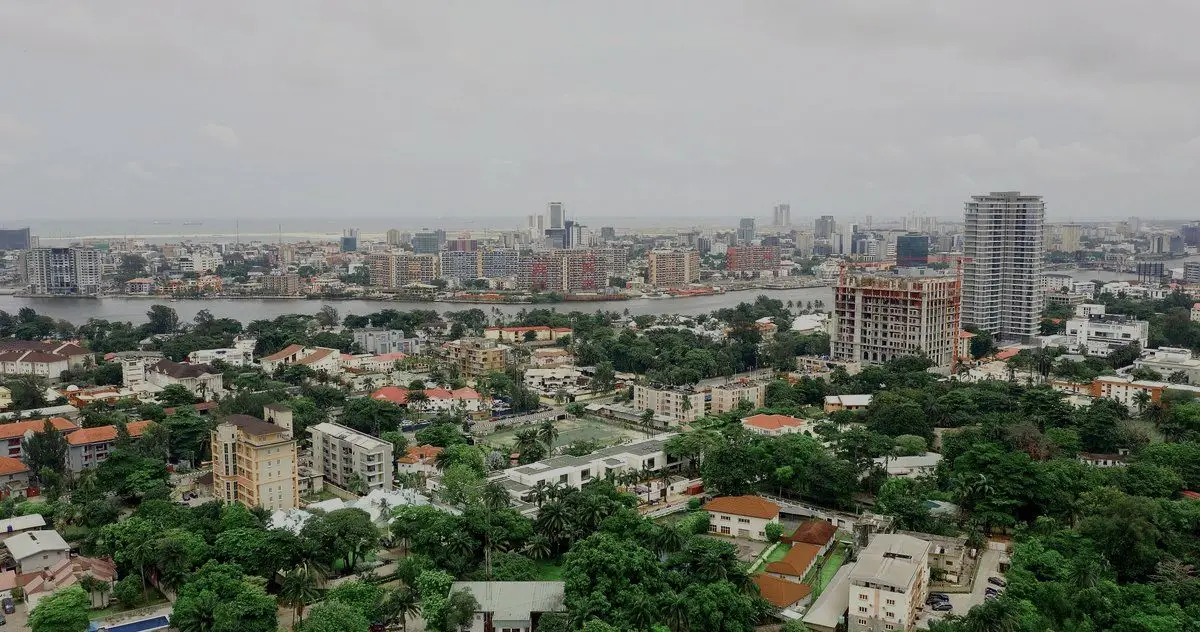 Aerial view over Ikoyi towards Victoria Island, Lagos, with low-rise roofs, towers and the lagoon
