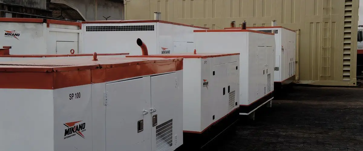 Rows of white containerised diesel generating sets in a yard in Nigeria